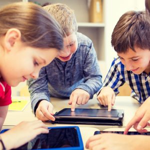 group of school kids with tablet pc in classroom